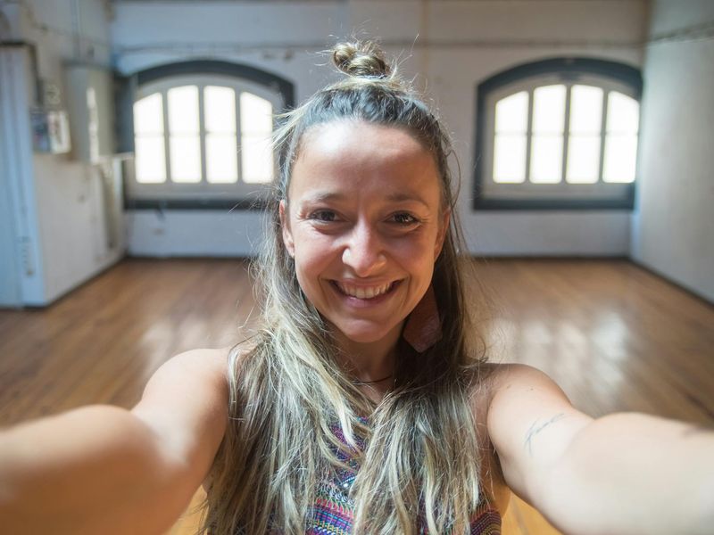 Wide view of a bright yoga studio with wooden floors